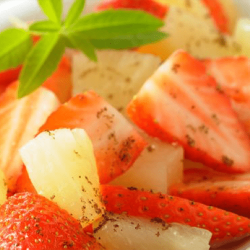 Salade de fruits frais (ananas, pommes, fraises) et menthe fraîche